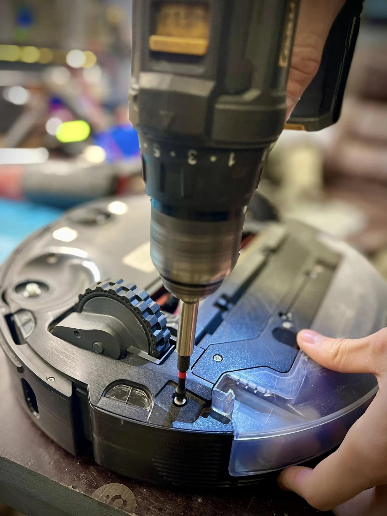 Tehniķis ar akumulatora skrūvgriezi noņem sānu paneli.